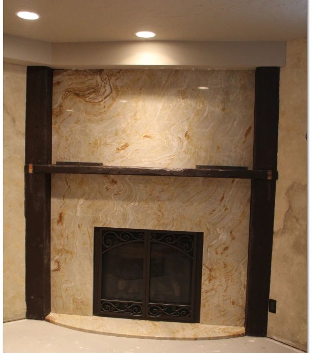 Cream marble fireplace with ornate veining and dark columns