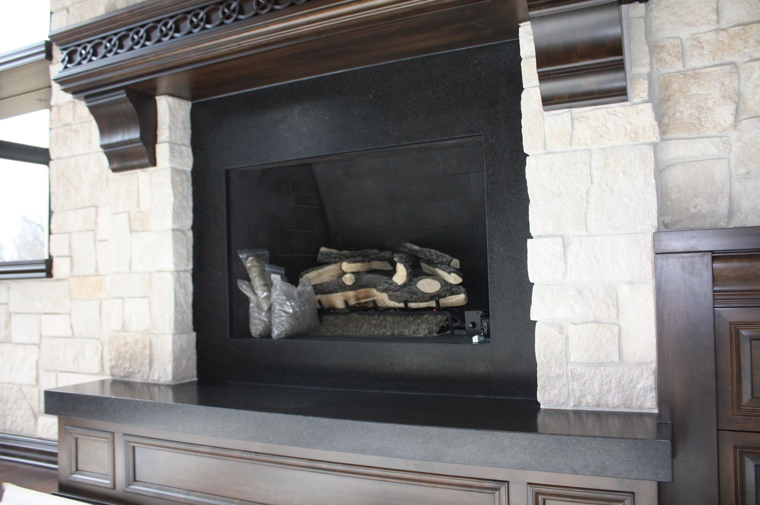 Fireplace with cream stone blocks and dark wood trim